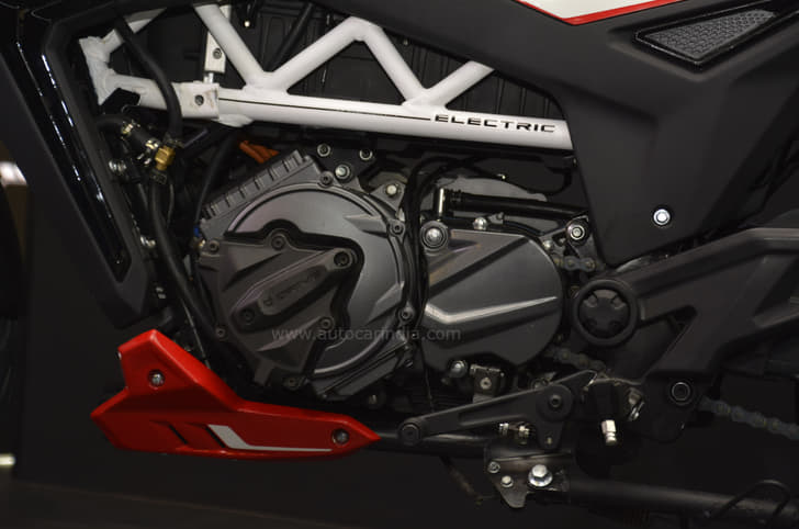 The battery is nestled behind the white frame, above the electric motor.